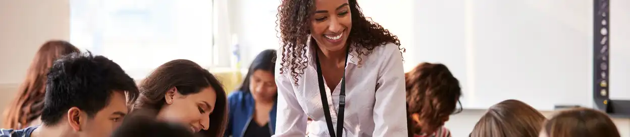 A teacher responds to one of her students in a busy classroom
