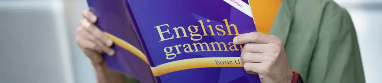 A man holding an English grammar book
