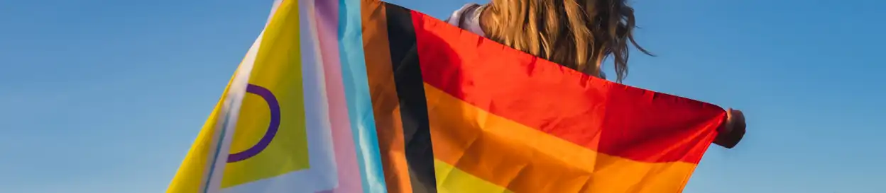 A person adorns the Pride flag