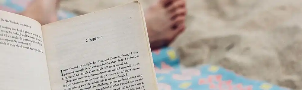 A book being read on a sandy beach