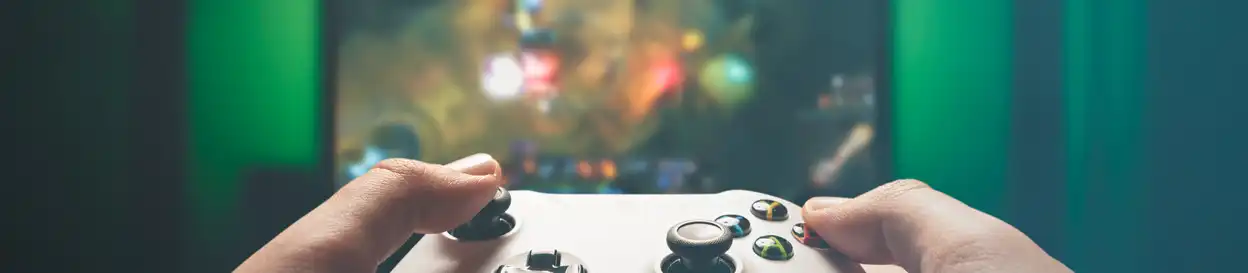 An XBOX controller held in front of a screen showing a sci-fi video game