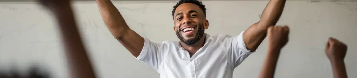 A teacher throws his arms up in celebration
