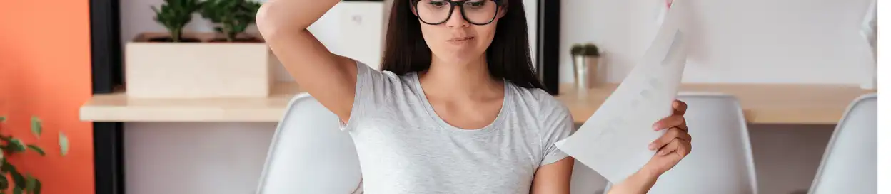 A confused teacher looks at some sheets of paper