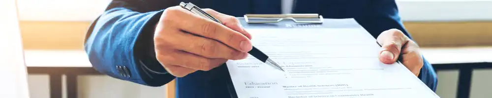 A man holding out a clipboard with a CV on it 