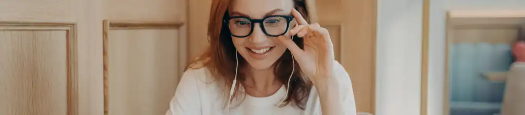 A woman conducts an online conversation, wearing earphones