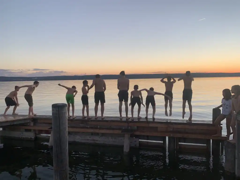 Young people jumping into a lake