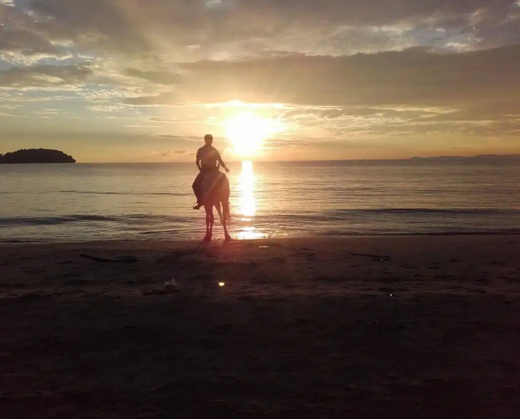 Daniel's friend on a horse at a beach in Cambodia