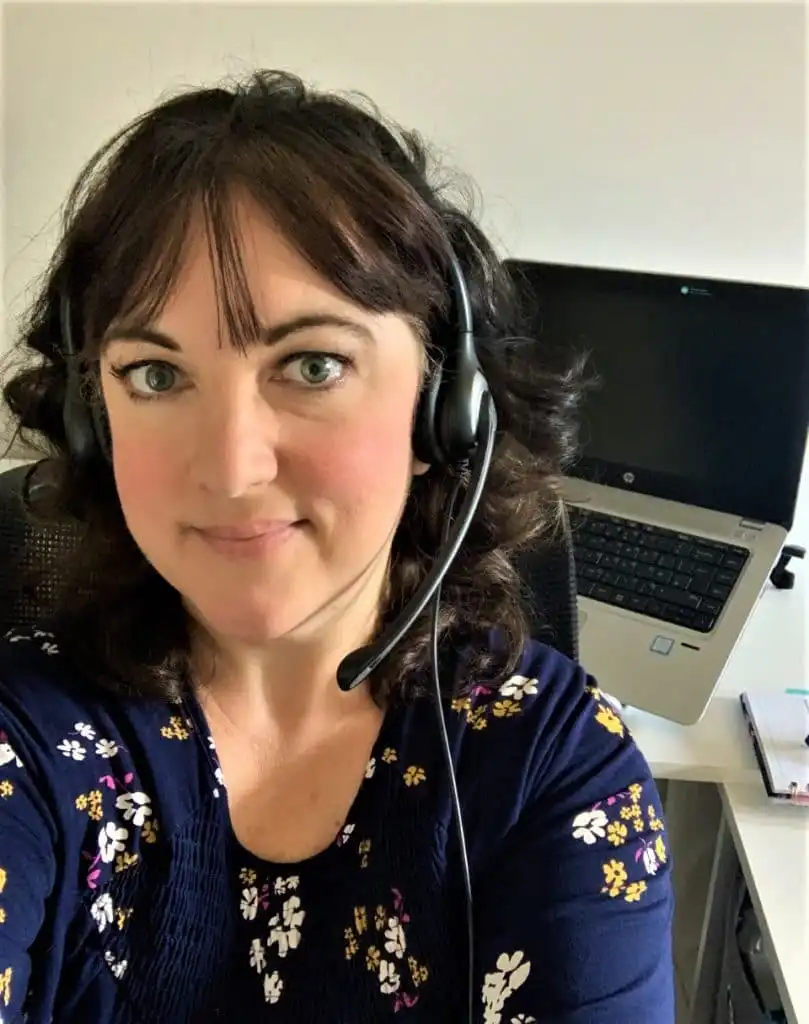 Online English teacher, Claire, wearing a headset and sitting in front of her laptop