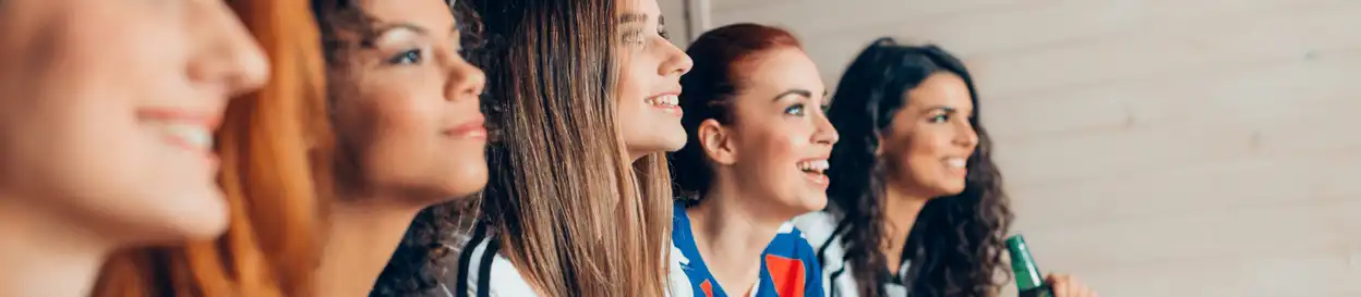 female football fans watching a game on TV