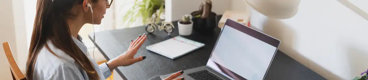 A woman sitting at her desk in front of a laptop