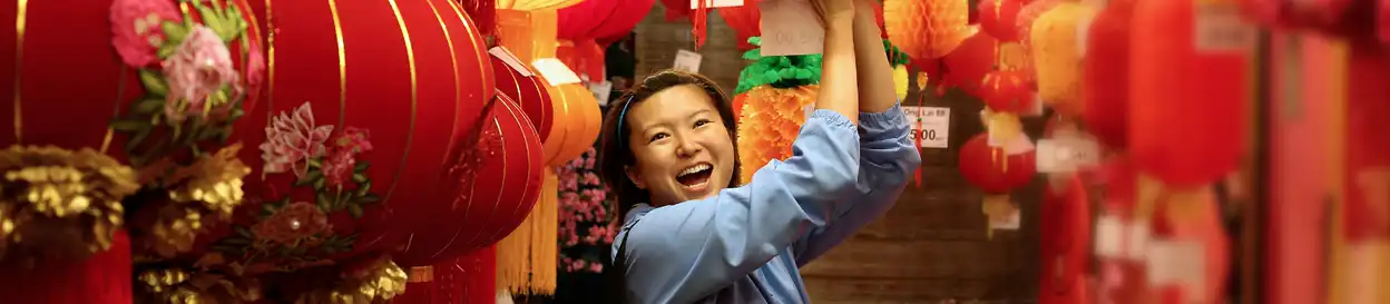 A woman smiling amongst Chinese lanterns