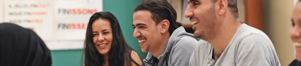 Adult learners smiling in a classroom