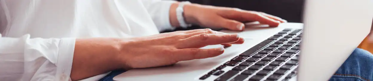 A woman typing on a laptop