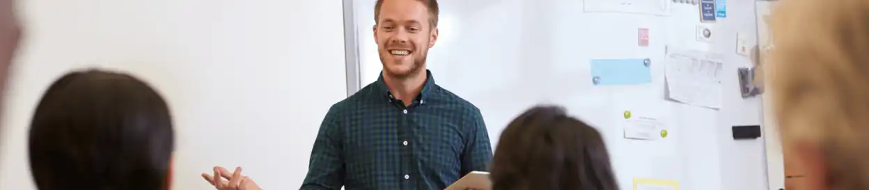 A male teacher in front of a whiteboard 