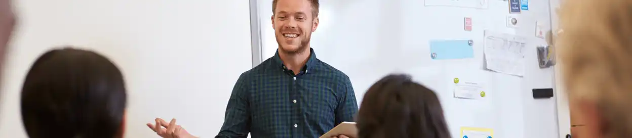 A male teacher standing in front of a whiteboard