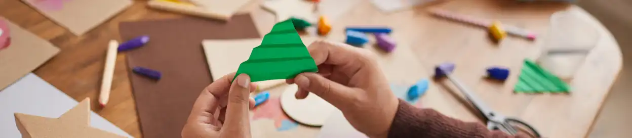 A child making a paper Christmas tree