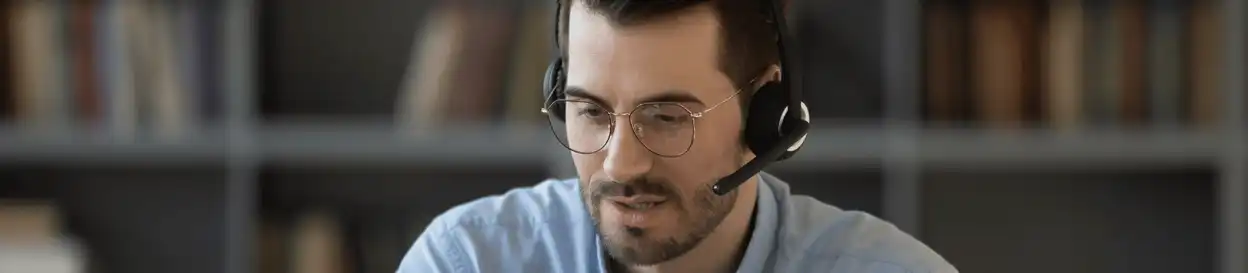 A man wearing with glasses wearing a headset and speaking