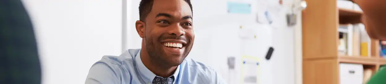 A male teacher smiling at a student