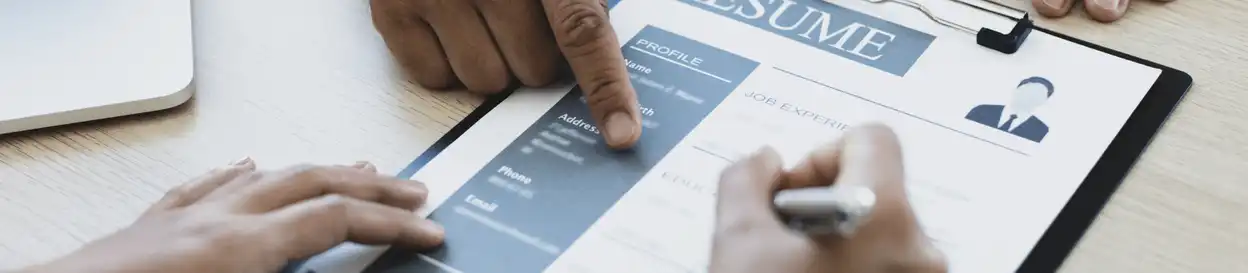 A resume on a table being pointed to by someone
