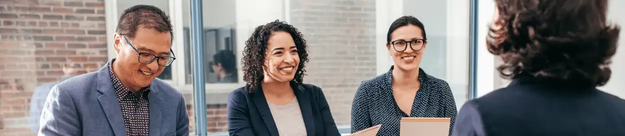 A panel of three interviewers interviewing a candidate