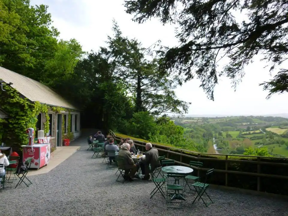 People sitting at tables in front of a French landscape